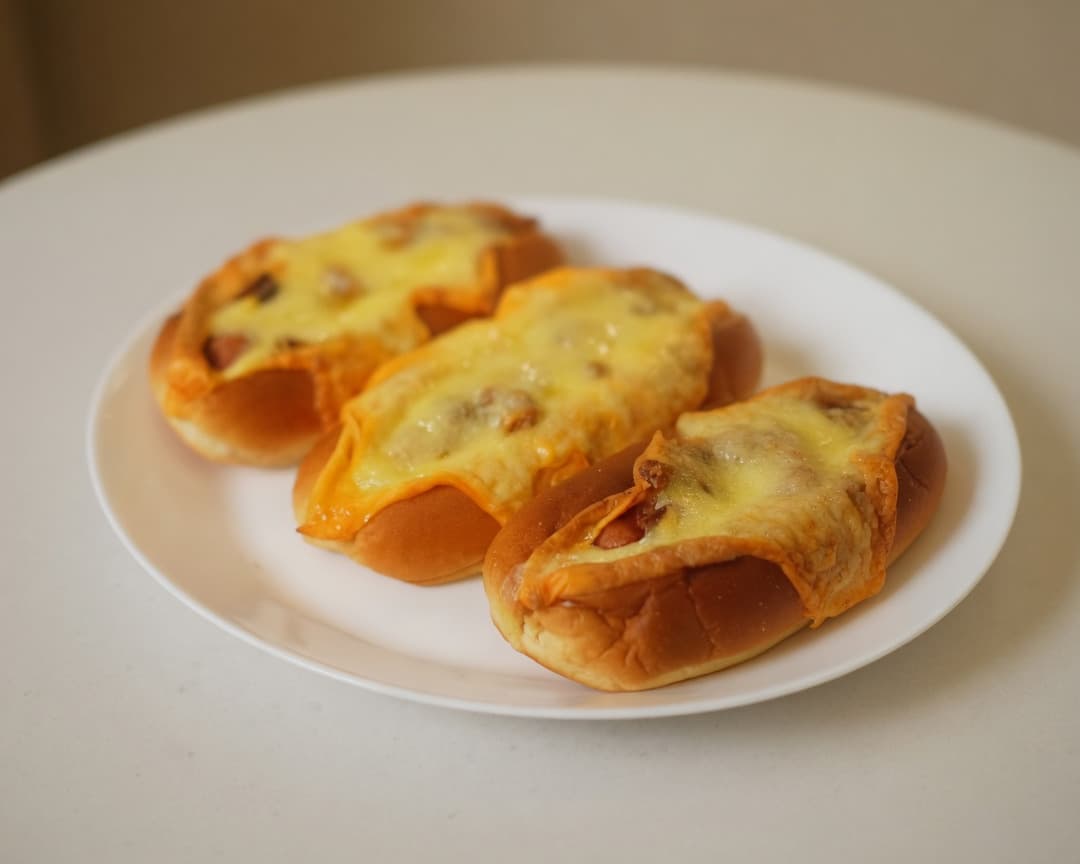 Crispy sausage buns pulled apart with melted cheese